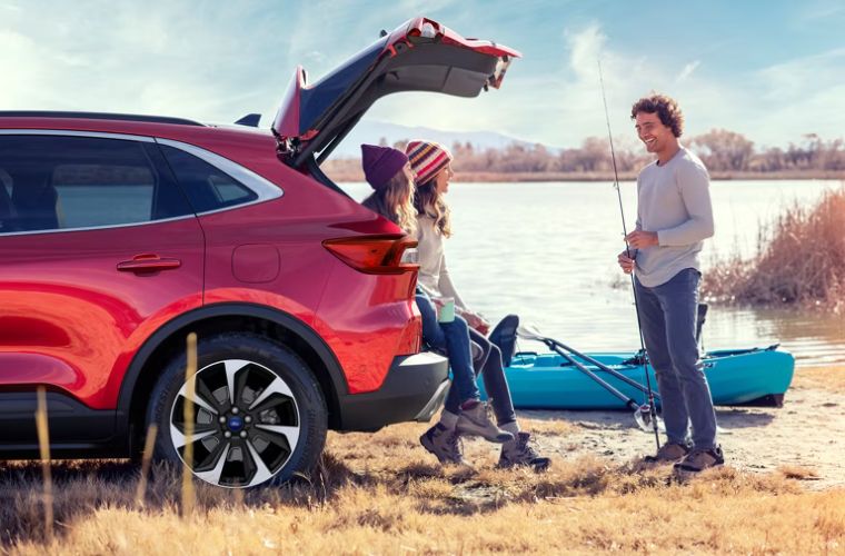Three people at the rear of a Ford SUV