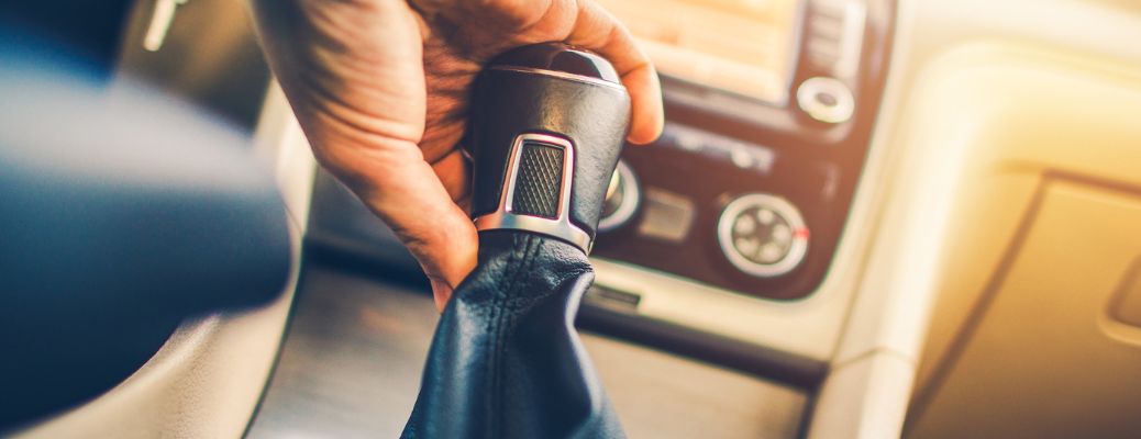 Hand of a man holding transmission of a vehicle