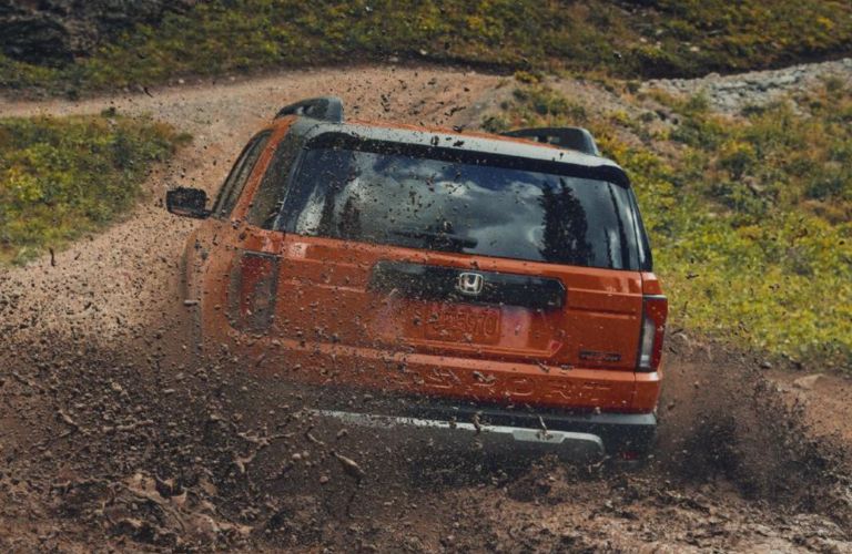 rear view of the 2026 Honda Passport off-roading in mud