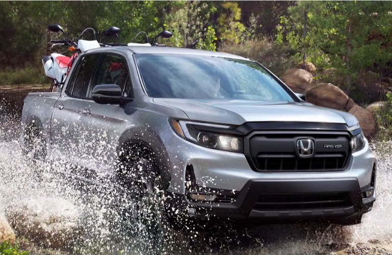 front view of a Honda off-roading in water