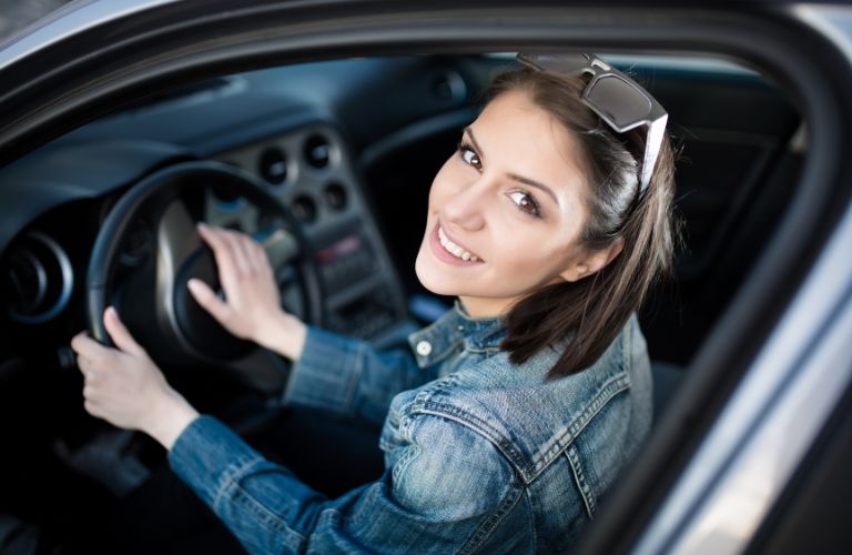 a woman smiling and looking up in driving seat