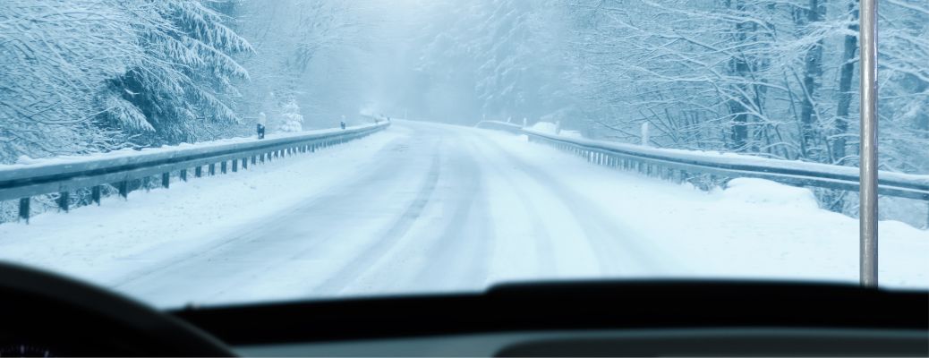 image of a snowy road from a car's windshield