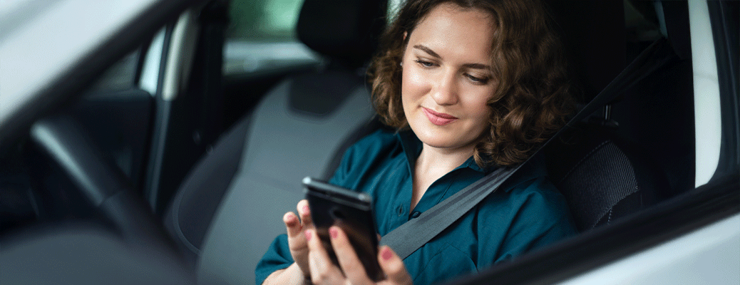 a woman in her car looking at her phone