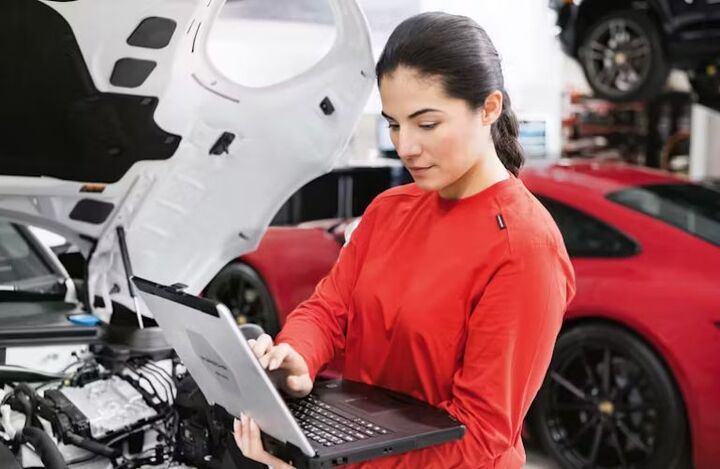 Mechanic checking off items on a list while inspecting an engine