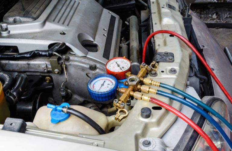 Mechanic filling AC liquid in a car