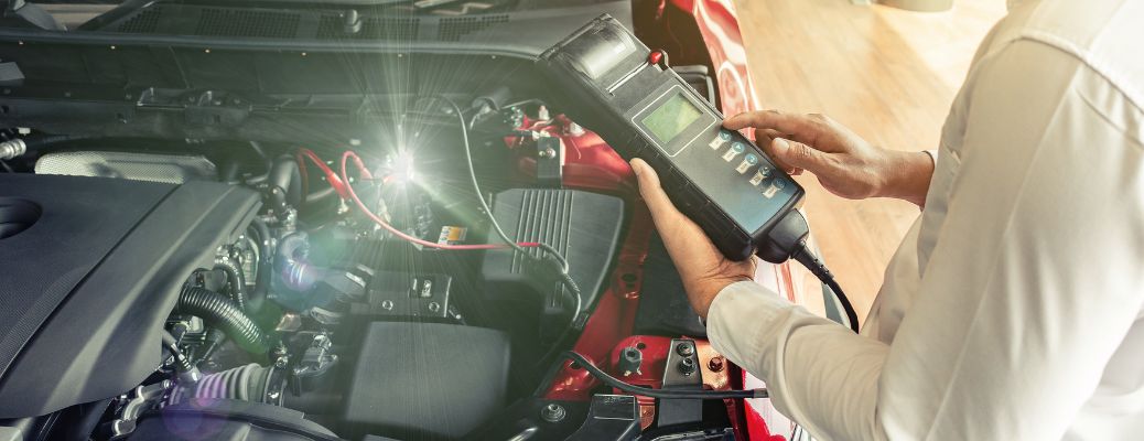 Technician inspecting a vehicle's battery