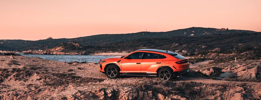 Lamborghini Urus SE parked on a rocky coastline overlooking the sea