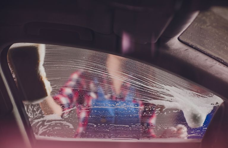 technician washing the windows of a car
