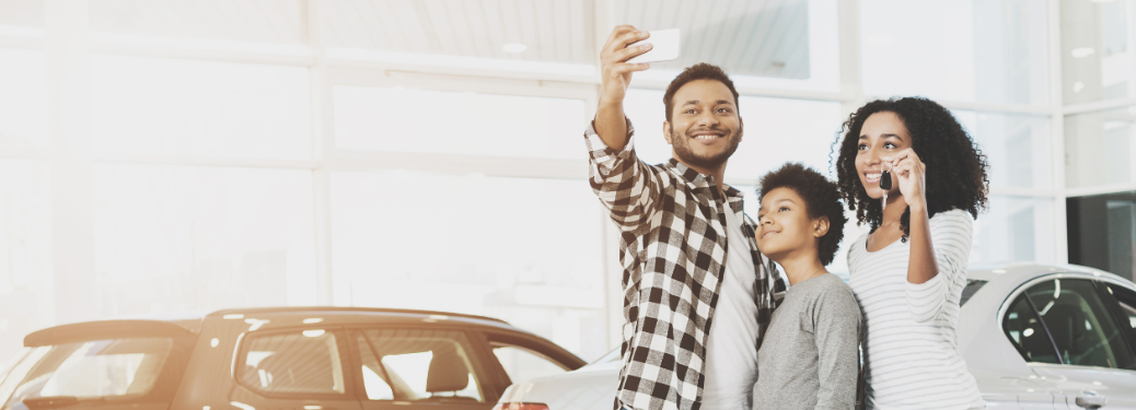 A family posing for a picture at a dealership