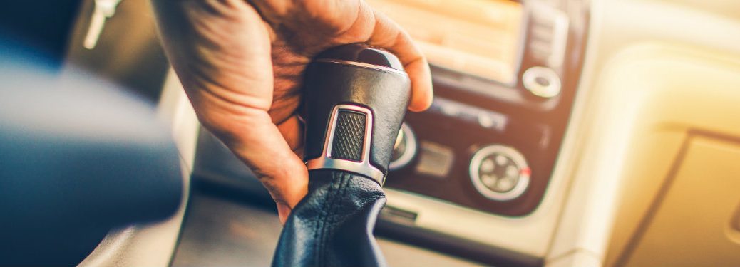 person changing gears in a car, seen from the level of the gear shifter
