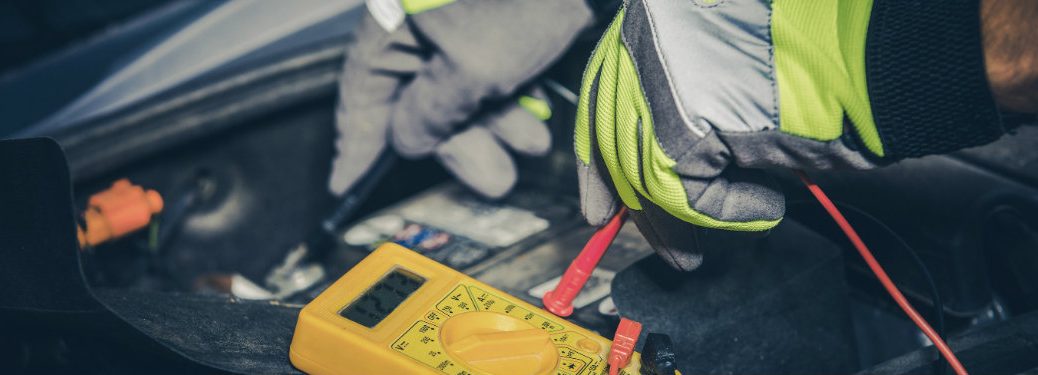 person checking the charge of a battery of a car