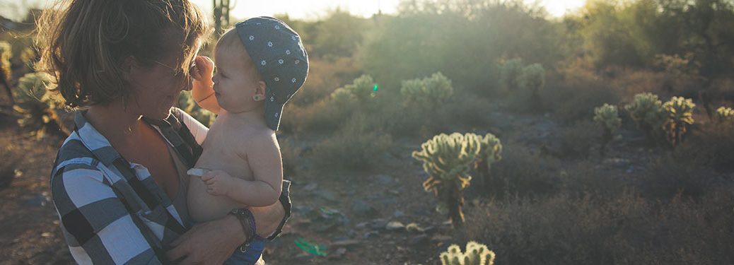 woman holding a child with a cheerful desert background