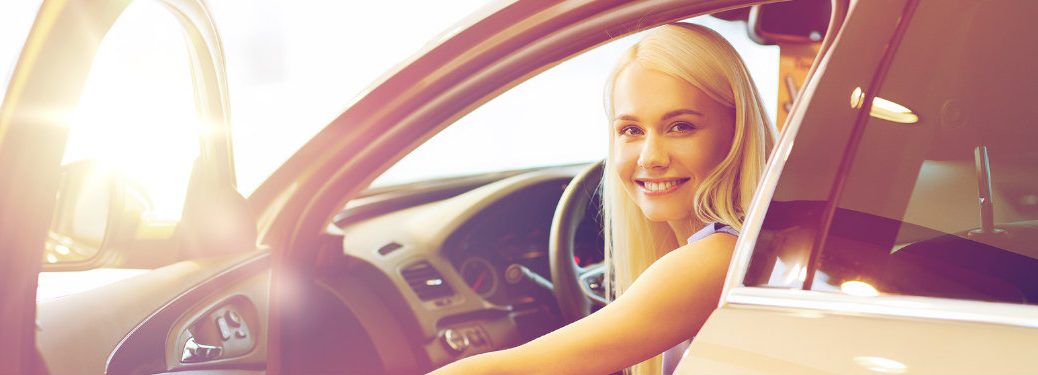 young woman smiling from a car