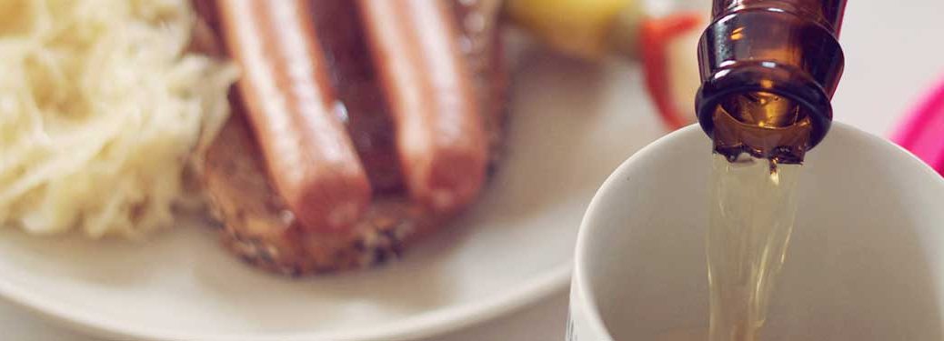 German food in the background with a pouring beer in the front