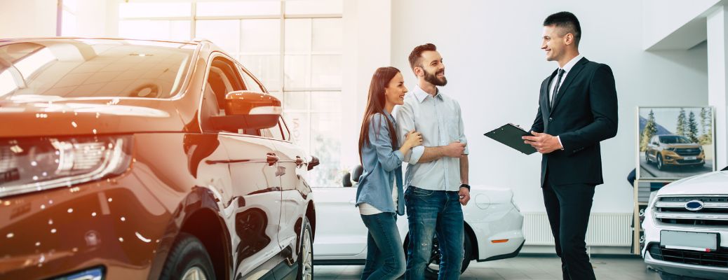 three people at a car dealership