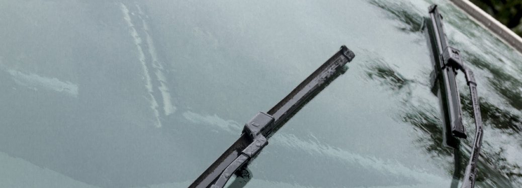 Two windshield wipers wipe a windshield.