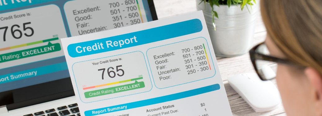 A woman gazes on a good credit report of 765.