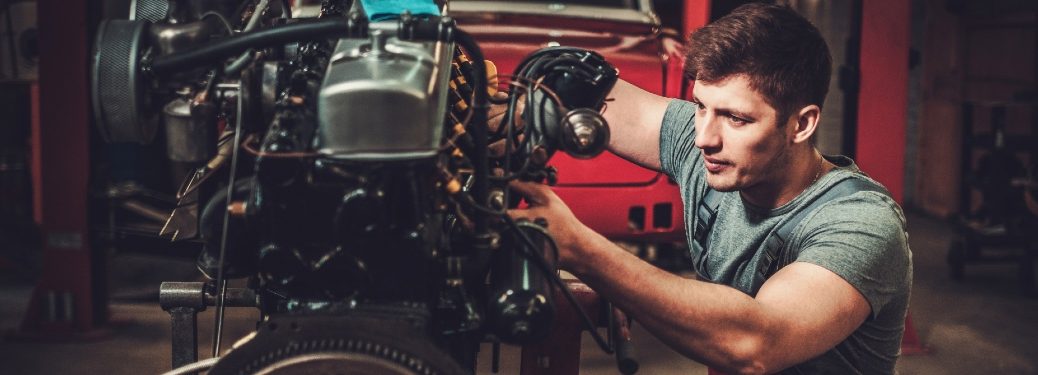 A mechanic toils away on an old drivetrain.