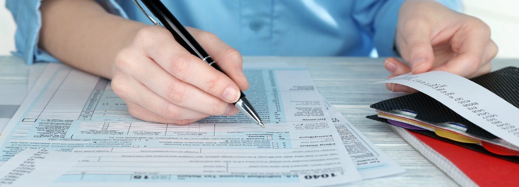 A woman writes out her taxes with many calculations