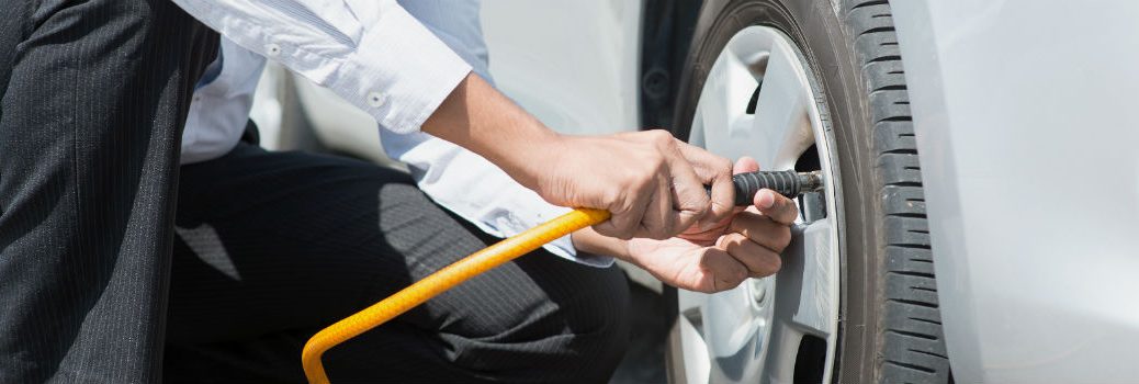 man checking tire pressure