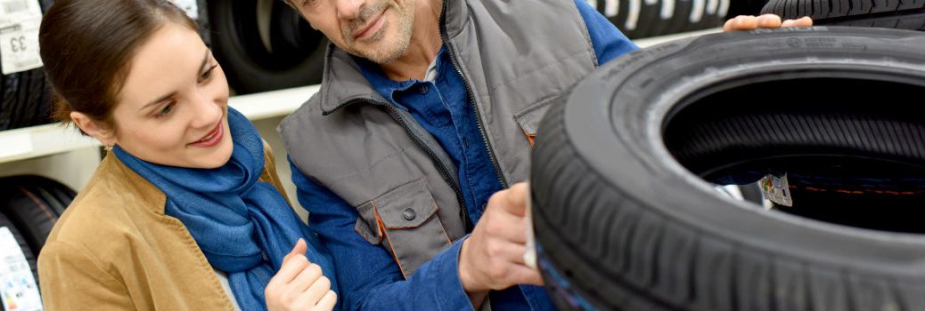man and woman looking at tires
