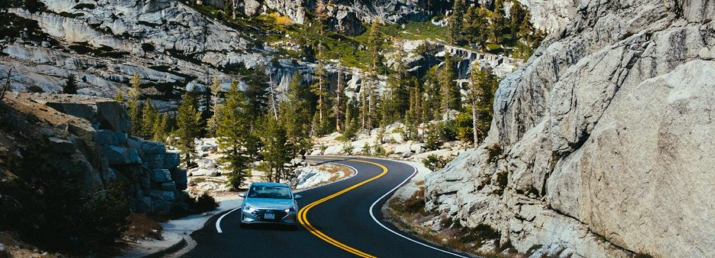 silver car driving on a curvy mountain road