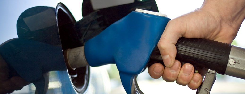 A stock photo of a person filling their car with gasoline.