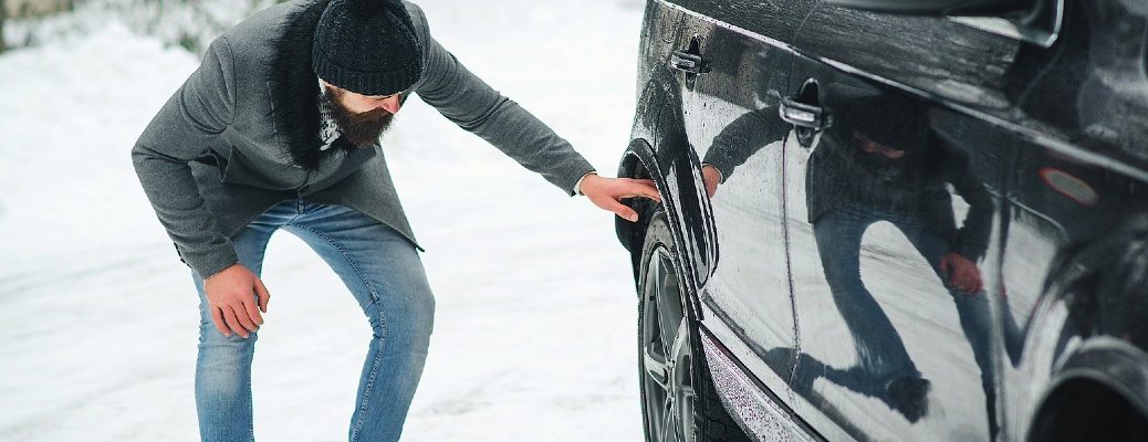 A stock photo of a person looking at a vehicle.
