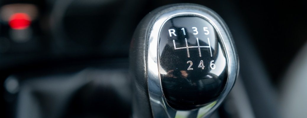 A stock photo of a gear lever in a vehicle with a manual transmission.