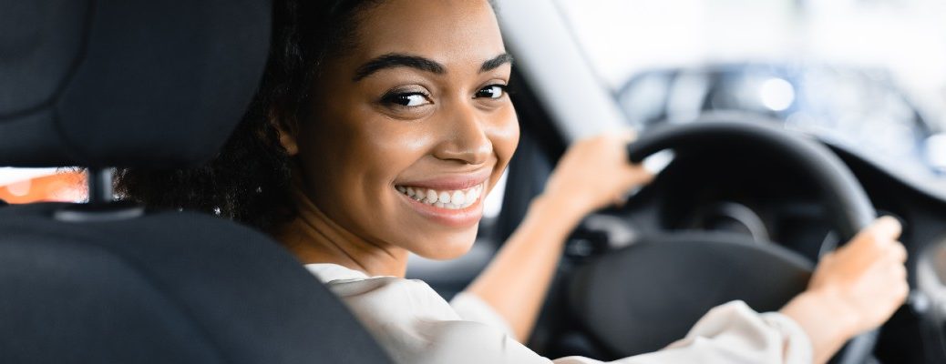 A stock photo of a person sitting behind the wheel of their car.
