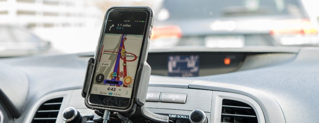 A photo of a smartphone attached to a dashboard showing navigation information.