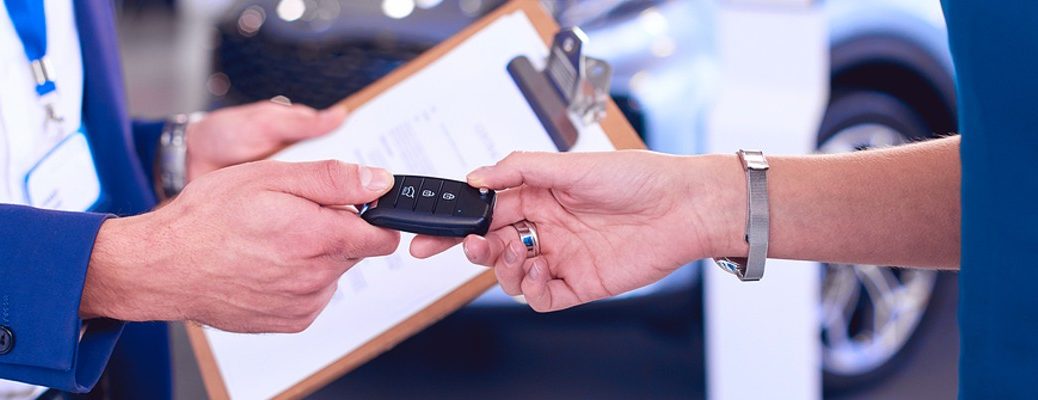 A stock photo of a person handing a new set of keys to another person.