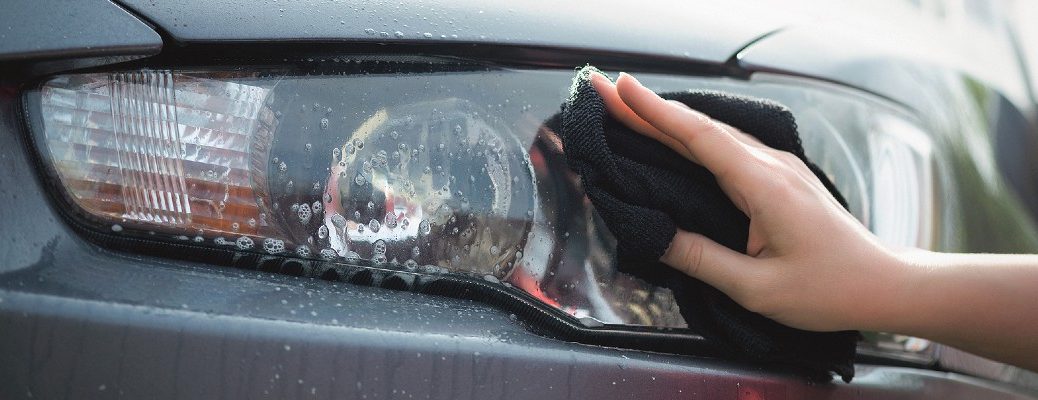 A stock photo of a person shining a headlight lens.