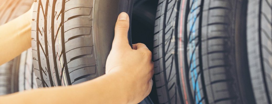 A stock photo of a person picking out a new tire.