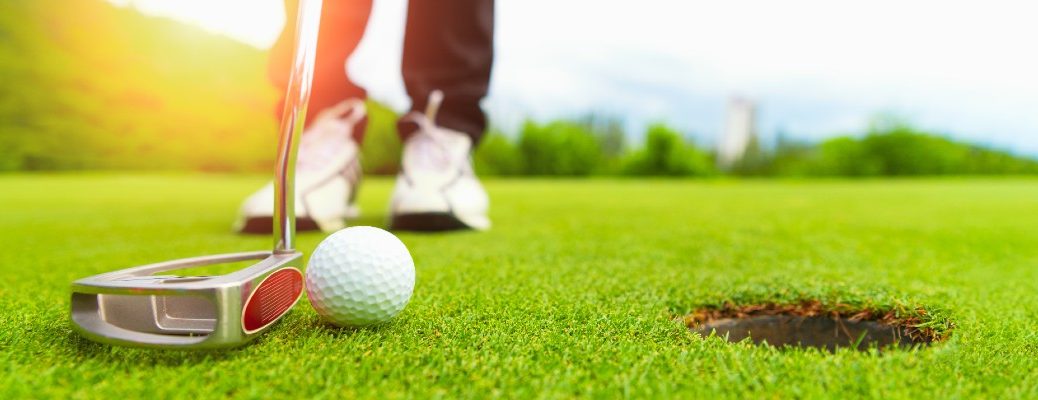 A stock photo of a person lining up a putt.