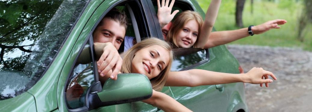 A happy family driving in a green car