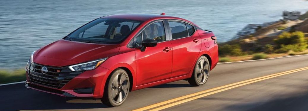 Used Nissan Versa Red driving on the road