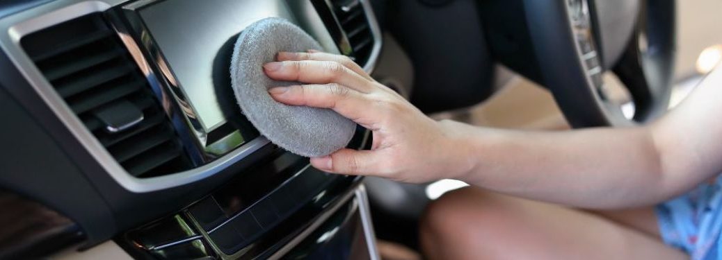 Woman cleaning car's dashboard