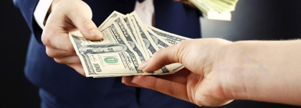 A person handing over cash to another person