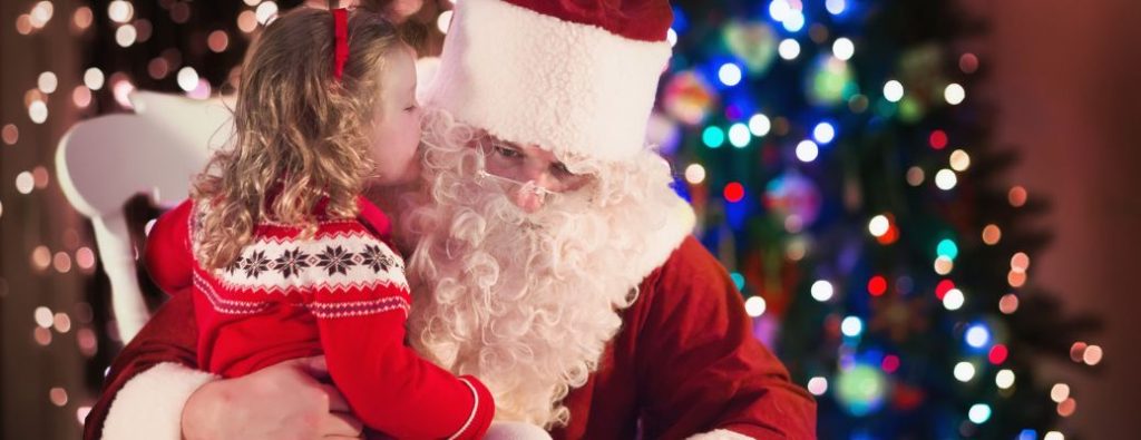 a kid whispering into Santa's ear