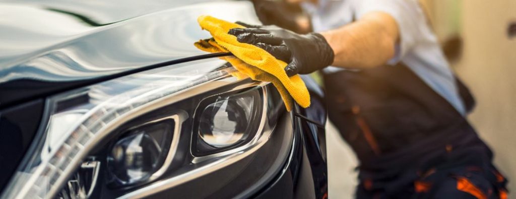 a person with a rag cleaning a car