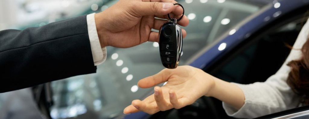 two hands passing a key fob to each other