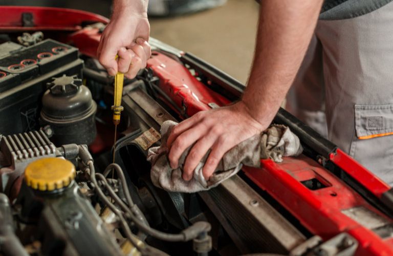 Technician checking a vehicle's oil