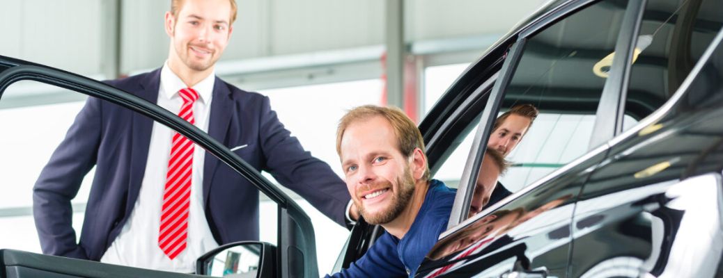 Salesperson showing a car to a customer