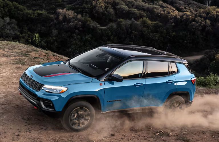 used Jeep vehicle in blue on dirt trail