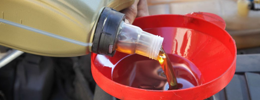 A stock photo of a oil being poured into an engine.