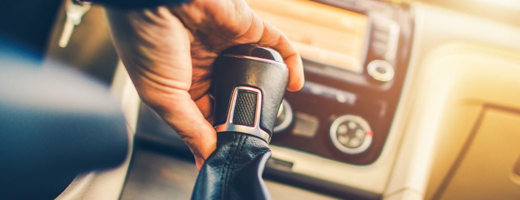 A stock photo of someone shifting gears with a manual transmission.
