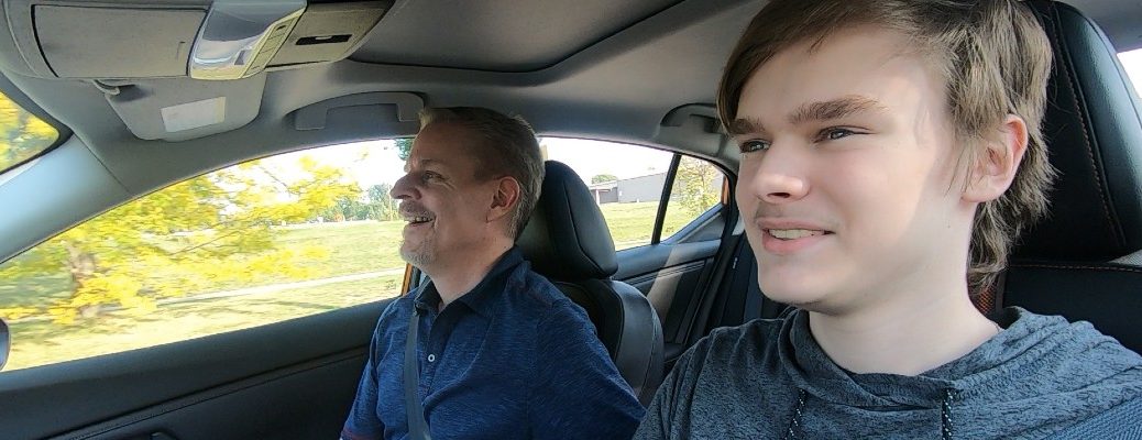 A photo of a young driver behind the wheel with an instructor.