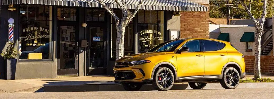 Side view of the 2024 Dodge Hornet parked outside a barber shop