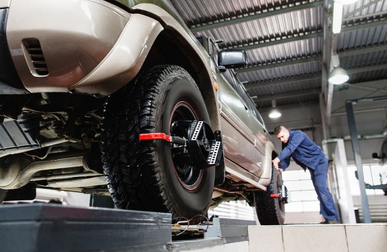 Technician aligning wheels of a vehicle